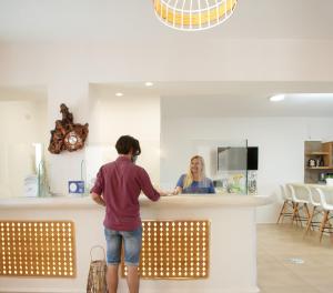 Una mujer parada en un mostrador en una cocina en Margaritari Hotel, en Agia Anna de Naxos
