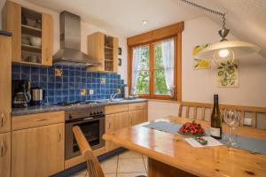 cocina con mesa de madera y azulejos azules en Ferienwohnung Henne, en Weißensberg