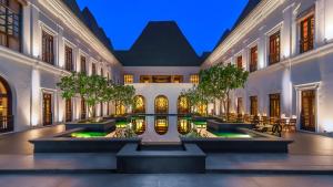 a courtyard in a building with trees and lights at Grand Hyatt Goa in Panaji