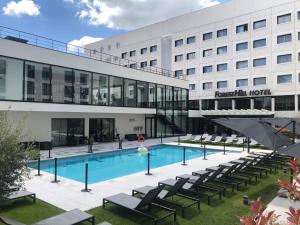 une image d'un hôtel avec une piscine et des chaises dans l'établissement Hôtel Forest Hill Meudon Velizy, à Meudon