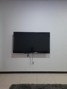 TV de pantalla plana colgada en una pared blanca en ريـــــم للشقق المفروشة والأجنحــة الفـندقيـة Reem Hotel, en Al Khobar