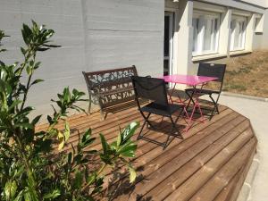 two chairs and a pink table on a deck at Centre Jean XXIII in Annecy
