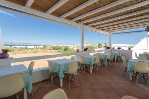 a restaurant with tables and chairs and a view of the beach at Margaritari Hotel in Agia Anna Naxos