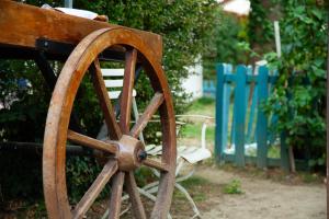 a wooden wagon wheel sitting next to a blue fence at LE FRUIT DEFENDU in Rueil-Malmaison