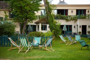 a group of chairs sitting in the grass in front of a building at LE FRUIT DEFENDU in Rueil-Malmaison