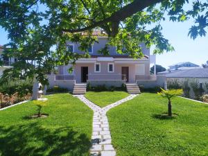 a house with a pathway in the yard at Villa Jullia & Rosa Vourvourou in Vourvourou