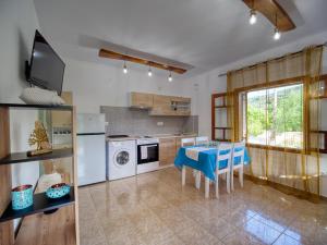 a kitchen with a table and blue chairs in it at Σπιτι στην εξοχη - Country House Milina in Milína