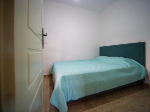 a bedroom with a bed with a green blanket and a door at Σπιτι στην εξοχη - Country House Milina in Milina