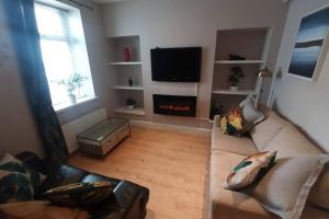 a living room with a couch and a fire place at Argyle House, 10 minute walk from city centre in Derry Londonderry
