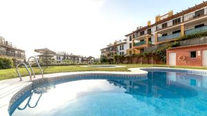 una piscina frente a unos edificios de apartamentos en Costa Esuri Golf y Playa V, en Ayamonte