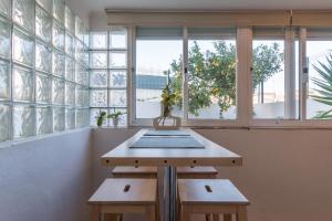 リスボンにあるVita Portucale ! 3 Bedroom Apartment with Private Terraceの窓のある部屋にあるテーブルと2つのベンチ