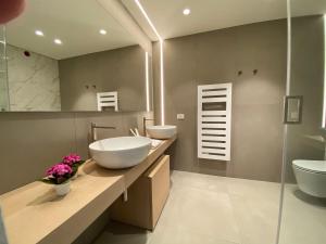 a bathroom with two sinks and two toilets at Sicilia's Art Hotel & Spa in Acitrezza
