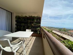a balcony with a white table and white chairs at Sicilia's Art Hotel & Spa in Acitrezza