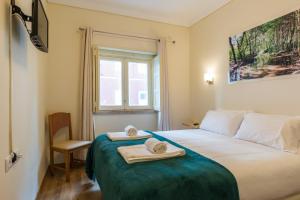 a bedroom with a bed with towels and a window at Vita Portucale ! 3 Bedroom Apartment with Private Terrace in Lisbon