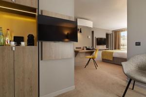 ein Hotelzimmer mit einem Schlafzimmer mit einem Bett und einem Schreibtisch in der Unterkunft Auteuil Tour Eiffel in Paris