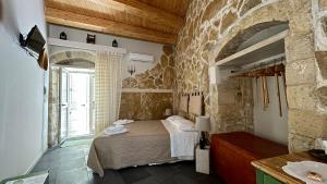 ein Schlafzimmer mit einem Bett und einem großen Fenster in der Unterkunft Cuturissi Hospitality & Wellnees in Ragusa