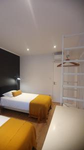 1 dormitorio con 2 camas con sábanas amarillas en T2P Pilar House, en Vila Nova de Gaia