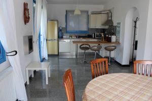 a kitchen with a table and chairs and a table and a table and a kitchen at Olive Beach Villa in Peyia