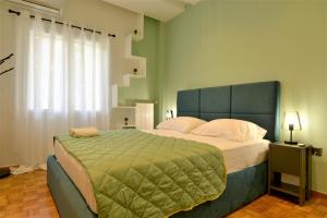 ein Schlafzimmer mit einem großen Bett und einer grünen Decke in der Unterkunft Cozy Apt in Ilisia with Urban Forest View in Athen