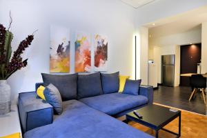 ein Wohnzimmer mit einem blauen Sofa und einem Tisch in der Unterkunft Cozy Apt in Ilisia with Urban Forest View in Athen