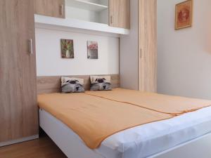ein kleines Schlafzimmer mit einem Bett mit gelber Bettwäsche in der Unterkunft Apartment Blue Sky in Novalja