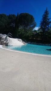 una piscina de agua azul en un parque en Duplex village vacances Grospierres, en Grospierres
