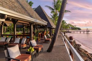 a beach with chairs, tables and umbrellas at Shangri-La Yanuca Island, Fiji in Voua