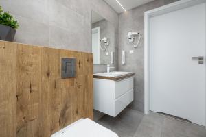 a bathroom with a white toilet and a sink at Amber Tiger Villa in Pobierowo