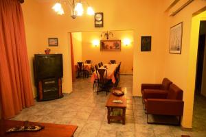 a living room with a table and a television at Argo Hotel in Perama