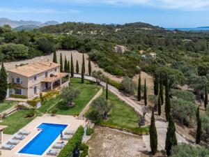 einen Luftblick auf eine Villa mit Pool und Bäumen in der Unterkunft Villa Muntalegre By homevillas360 in Pollença