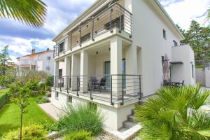 Casa blanca con balcón y algunas plantas en Residence Veglia en Krk