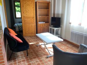 a living room with a table and chairs and a tv at Gites Le Pagus in Simeyrols