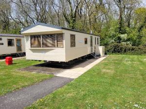 um pequeno reboque branco estacionado num quintal em "Trinity" at Whitecliff Bay Isle of Wight- Yarborough View 4 em Bembridge