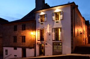 a white building with windows on a street at Sete Artes by Como en Casa in Santiago de Compostela