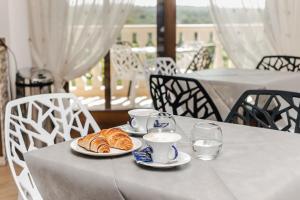 una mesa con dos platos de cruasanes y vasos de agua en Holiday Gli Archi, en Fasano