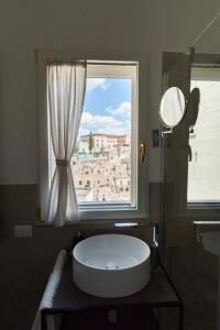 a bathroom with a large white tub in front of a window at Antica Pepice in Matera