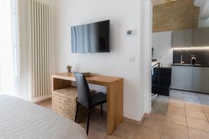 a bedroom with a desk with a television on a wall at Antica Pepice in Matera