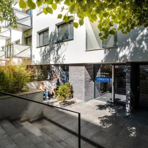 a building with two children sitting on a bench in front of it at Smart & Green Living by Ambiente in Bratislava