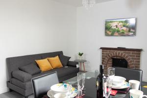 亞伯丁市的住宿－Vion Apartment - Farquhar，带沙发的客厅和带壁炉的餐桌