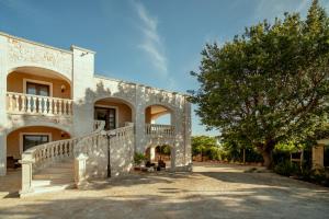 a building with stairs and a tree in front of it at Holiday Gli Archi in Fasano