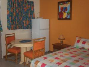 a kitchen with a table and a white refrigerator at Point Village, Negril, Jamaica in Negril +43 photos