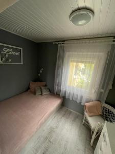 a bedroom with a bed and a window at Ágnes Nyaralóház in Balatonmáriafürdő