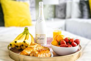 een schaal fruit en een fles champagne bij Central Leamington Spa House with Free Parking, Fast Wifi, Smart TV with Free Netflix and Garden by Yoko Property in Leamington Spa