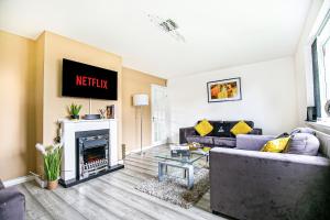 a living room with a couch and a fireplace at Central Leamington Spa House with Free Parking, Fast Wifi, Smart TV with Free Netflix and Garden by Yoko Property in Leamington Spa