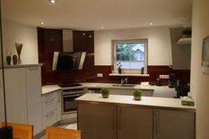 a kitchen with white cabinets and a sink and a window at Ferienhaus Schönebühl in Oberreute