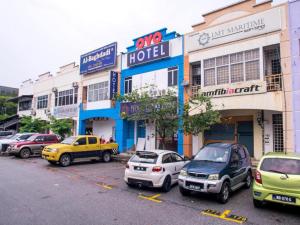 un groupe de voitures garées dans un parking devant les bâtiments dans l'établissement OYO 90281 Hotel Taj seksyen 13, à Shah Alam