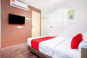a bedroom with a bed and a tv on a wall at OYO 90281 Hotel Taj seksyen 13 in Shah Alam
