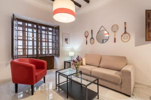un soggiorno con divano e sedia rossa di BnS Dauro Suites a Granada