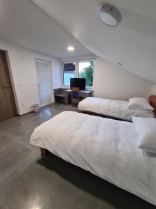 a bedroom with two beds and a desk with a computer at Gostišče pri Rudiju in Šalovci