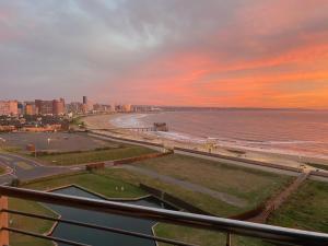 a view of a beach at sunset with a city at Quayside 1001 Durban Point in Durban